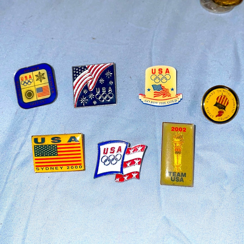 7 USA Olympic collectors pins from different years.